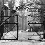Sloganul lagărului Auschwitz-Birkenau: Arbeit Macht Frei (Munca te eliberează)